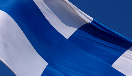 Lähikuvassa Suomen lippu liehuu