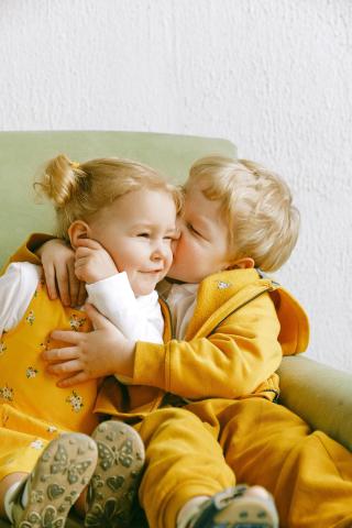 Kuva lapsista istumassa ja halaamassa toisiaan