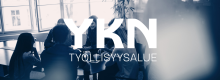 Kuvassa ihmisiä istumassa pöydän ympärillä